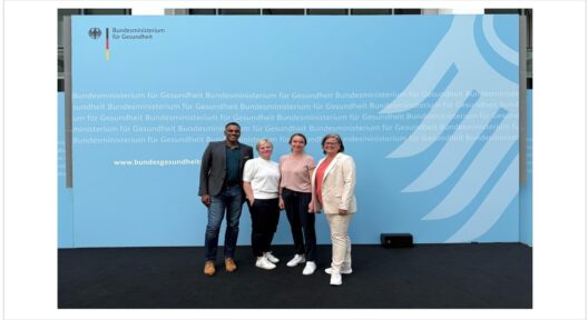 Group picture of telemedicine team in front of the German Minsitry of Health banner