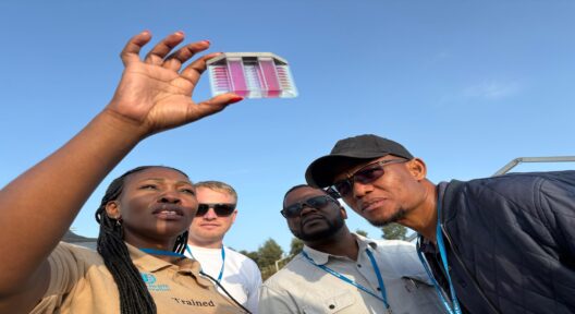 Eine Gruppe von Menschen steht draußen und schaut sich Wasserproben an