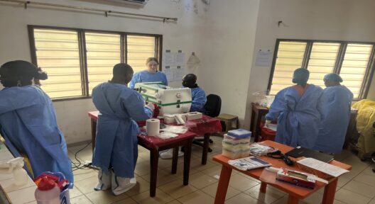 Group of people in protective gear are unpacking and arranging laboratory equipment