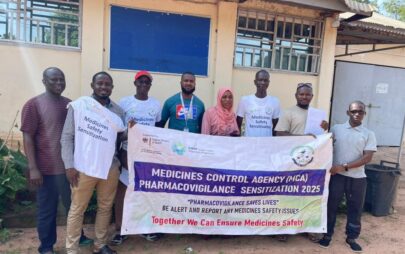 Eine Gruppe von Personen steht vor einem Gebäude und hält ein Banner mit Aufschrift: "Medicines Control Agency - Pharmacovigilance Sensitizateion 2025""